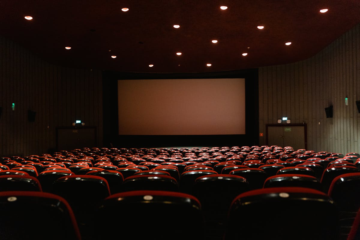 Sala de cinema vazia com tela grande, representando o uso de projetor 8K para exibição de alta definição